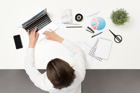 Um trabalhador de escritório feminino digitando na mesa