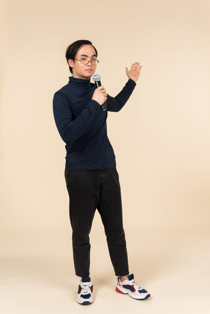 Young asian man speaking into a microphone