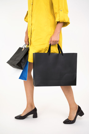 Woman's legs in black shoes holding shopping bags