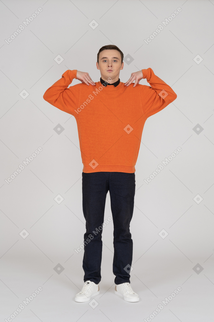 オレンジ色のスウェットシャツに立っている若い男