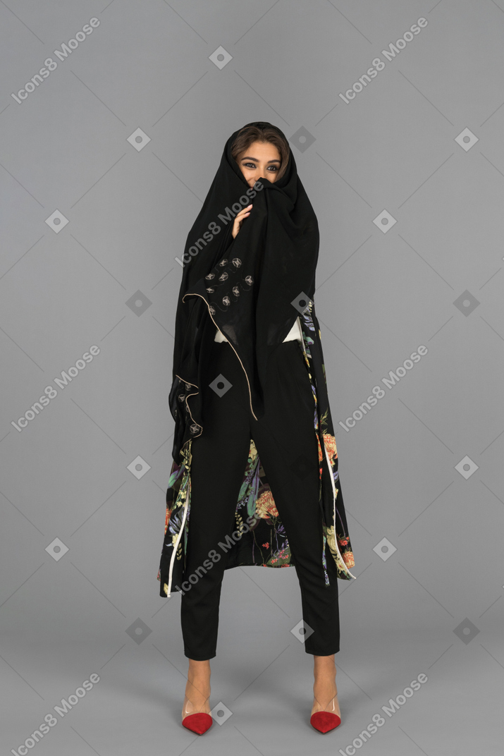 Young woman wrapped in black headscarf