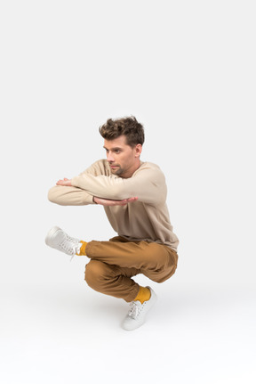 Young guy sitting in hip hop dance position