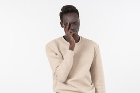 A young black man in a grey sweater standing alone on the white background