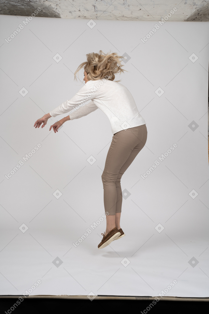 Femme en vêtements décontractés sautant