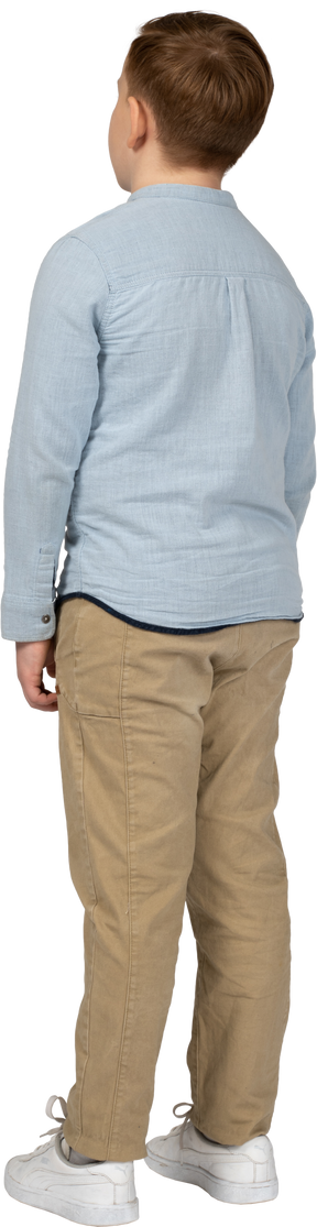 Back view of a boy in casual clothes standing still