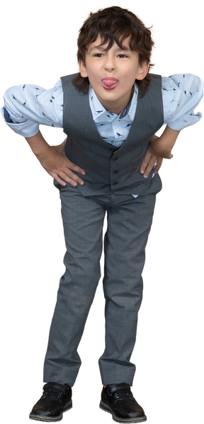 一个身穿灰色西装、双手叉腰、露出舌头的男孩的正面图