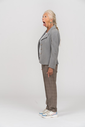 Senhora idosa de terno posando de perfil