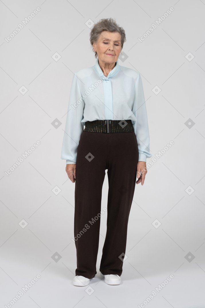 Old woman standing with eyes down