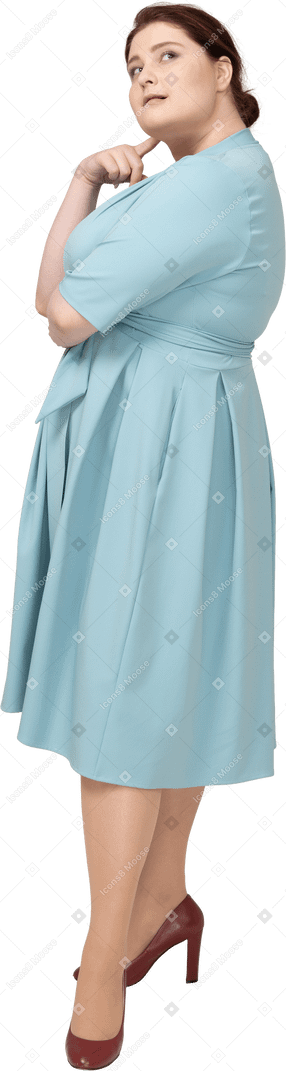 一个穿着蓝色连衣裙做梦的女人的侧视图