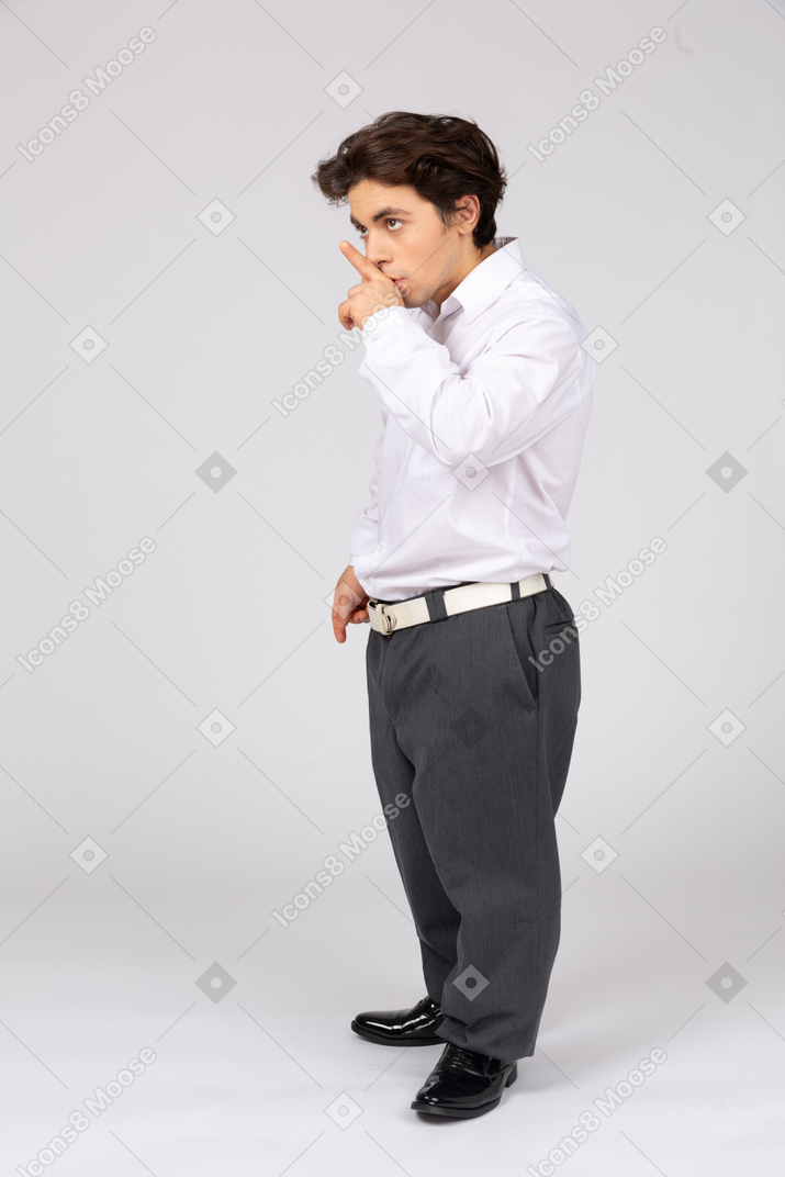 Side view of businessman with finger on lips