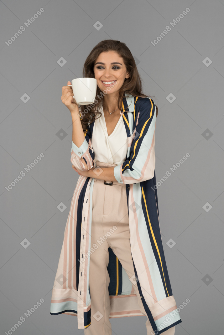 Cheerful arab woman holding white cup