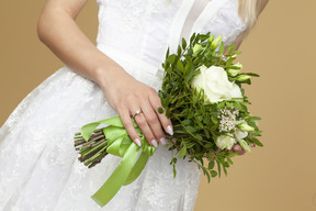 Braut mit einem ring auf einer hand, die hochzeitsblumenstrauß hält