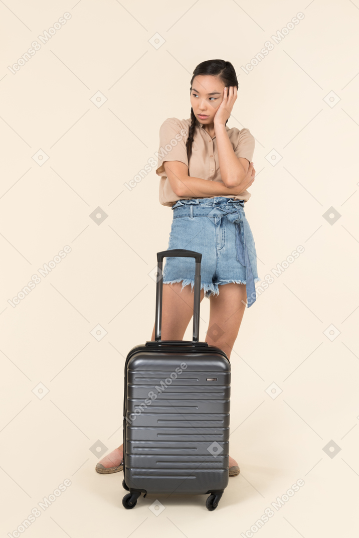 가방 근처에 서 걱정 된 젊은 여자