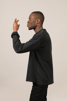 Side view of man gesturing with hand and speaking