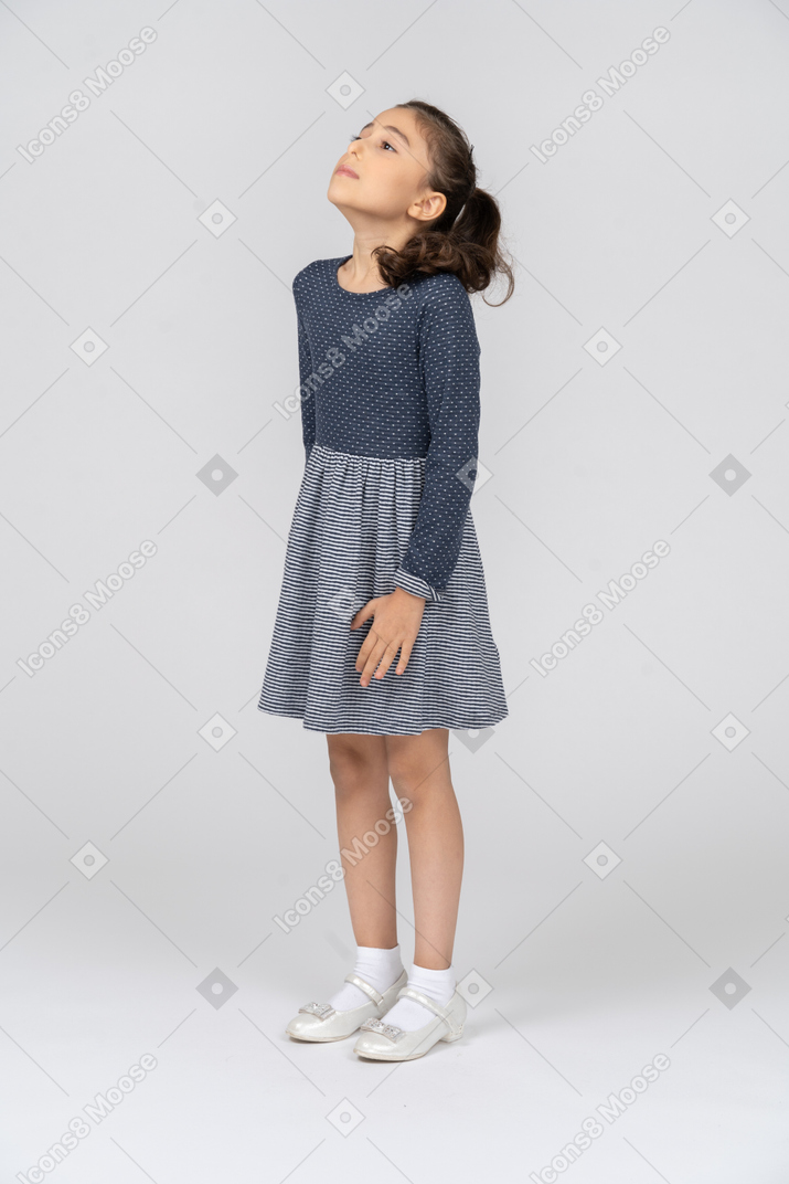 Three-quarter view of a girl raising shoulders and looking up