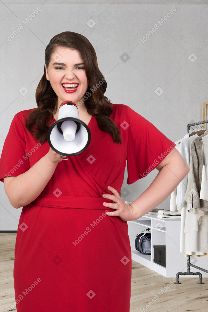 Mulher em um vestido vermelho segurando um megafone