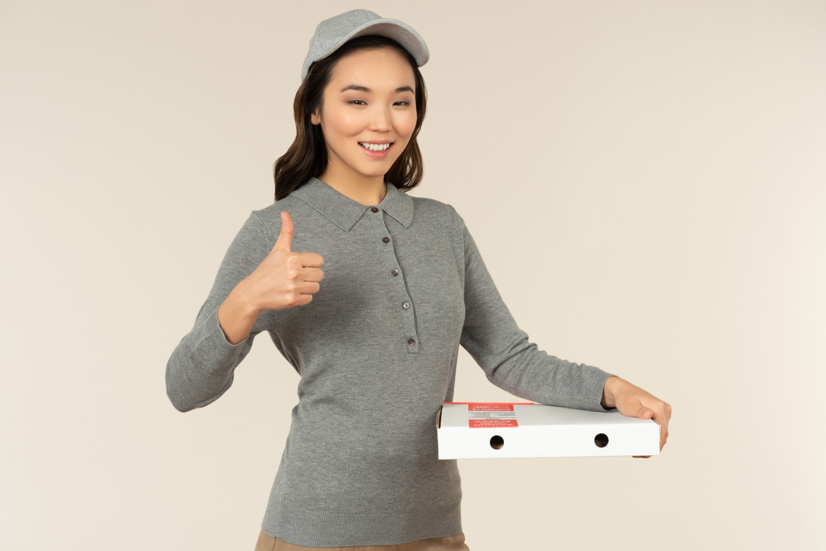 Young asian pizza delivery girl carrying pizza and showing thumb up