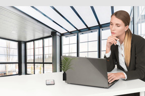 A business woman sitting at a desk with a laptop