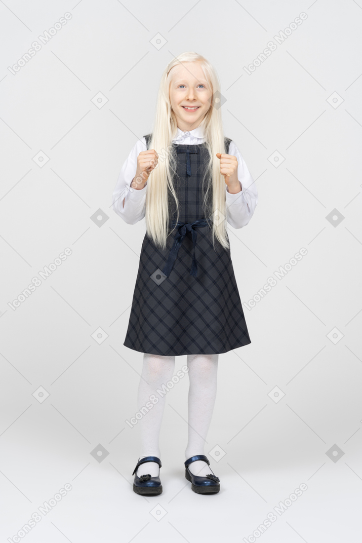 Schoolgirl looking excited with her fists up