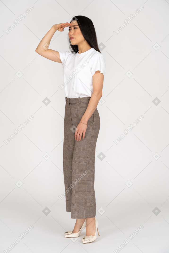 Three-quarter view of a young woman in breeches looking for something