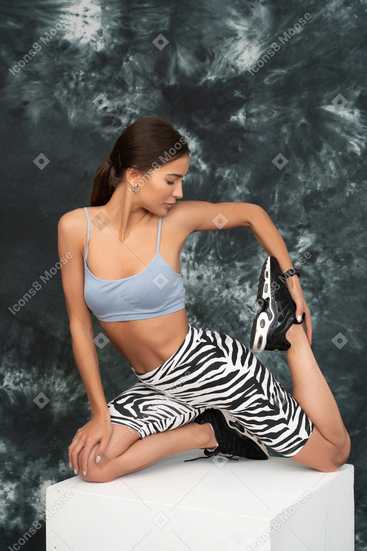 Une athlète féminine qui s'étend des hanches en regardant son pied