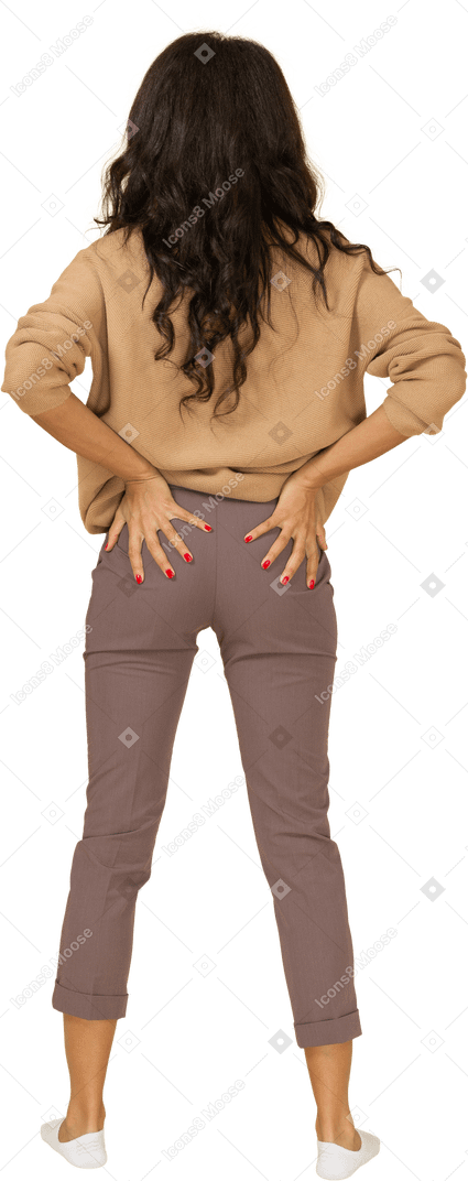 皮肤黝黑的年轻女性，将手放在屁股上的后视图