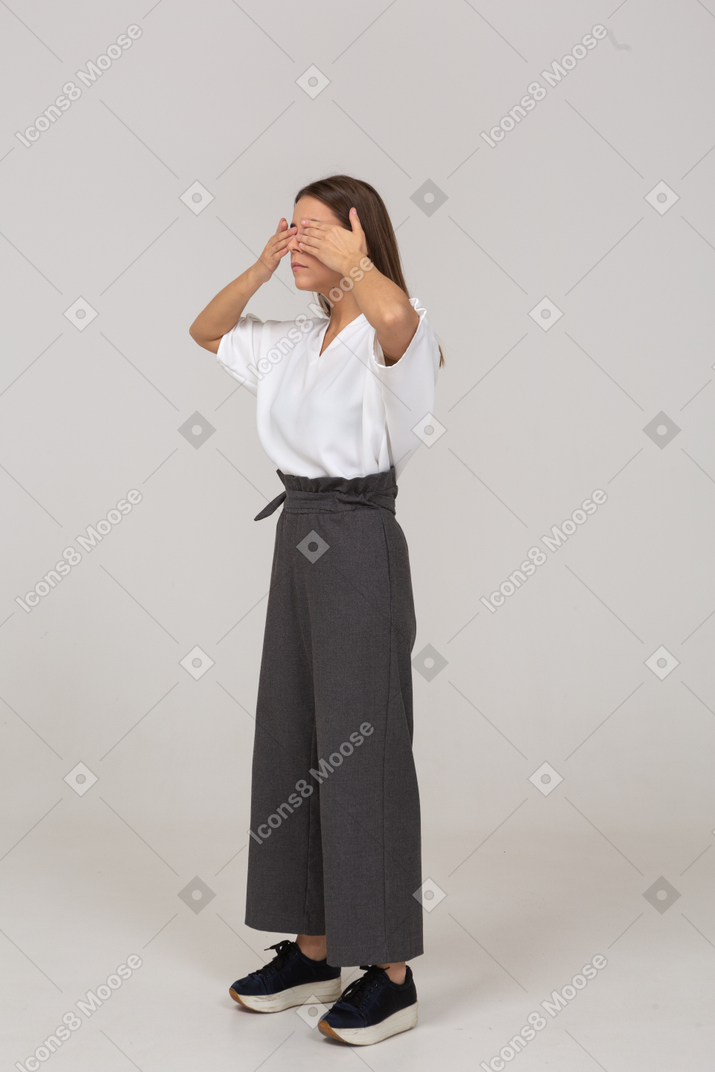 Three-quarter view of a young lady in office clothing shutting her eyes
