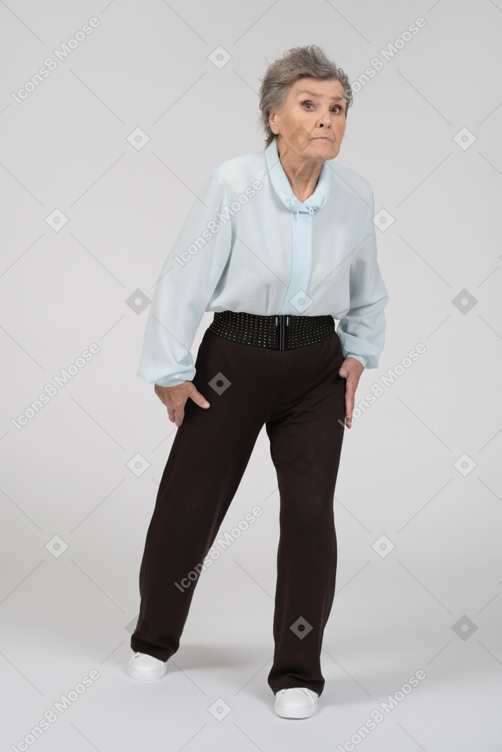 Three-quarter view of an old woman stepping forward with an expectant expression
