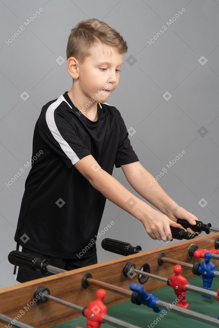 Vista di tre quarti di un ragazzo che gioca a biliardino