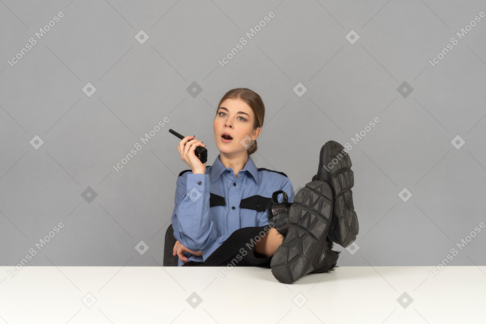 A female security guard sitting at her desk