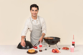 Hombre caucásico joven cocinando barbacoa