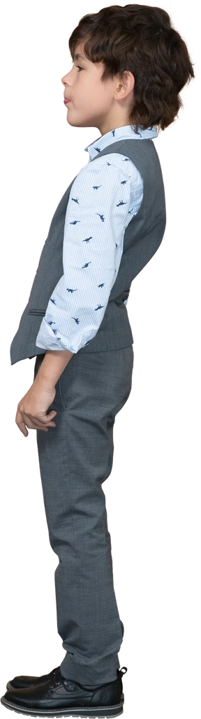 Cute boy in grey suit standing in profile