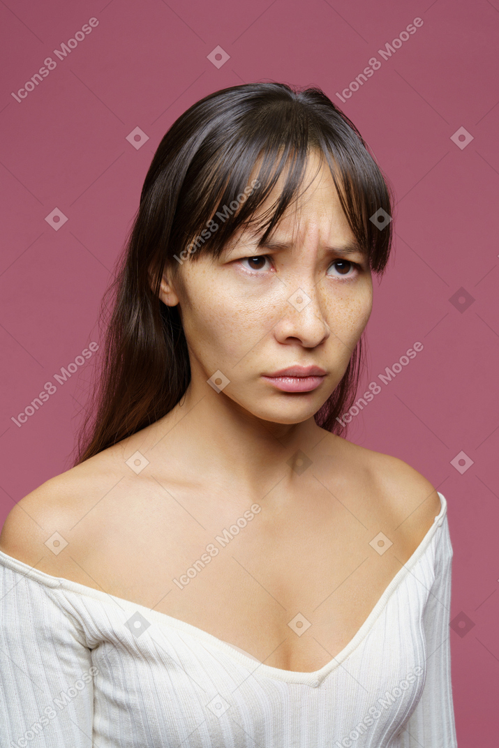 Gros plan d'une femme d'âge moyen mécontent de tricoter les sourcils et à côté
