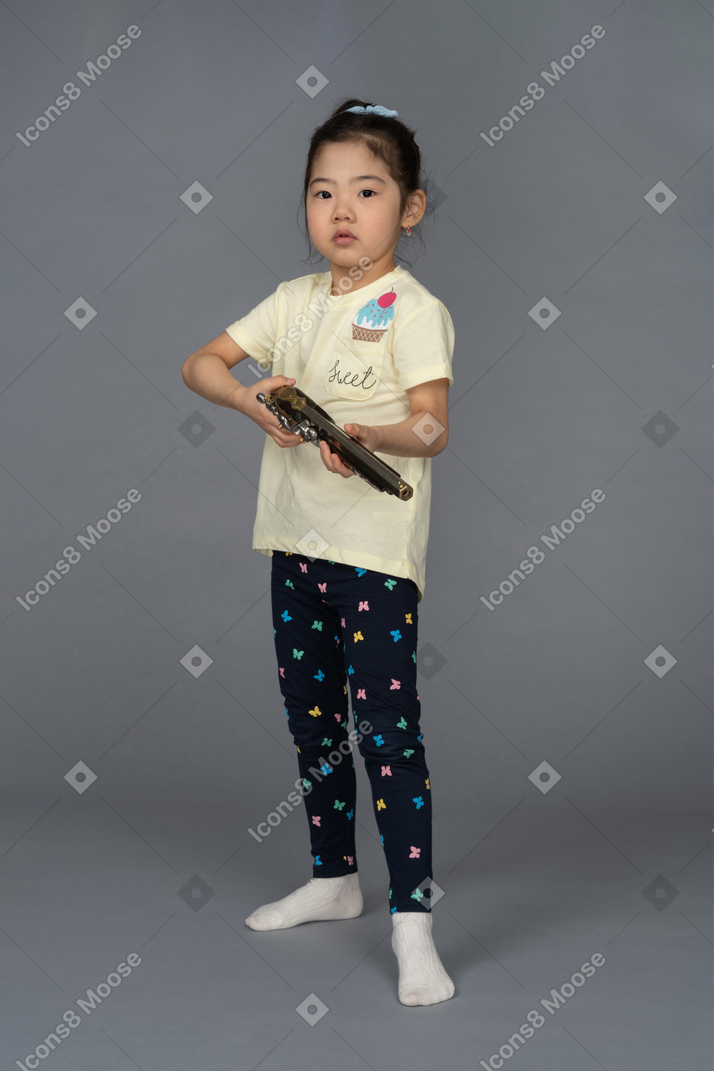 Portrait d'une petite fille tenant un fusil de chasse