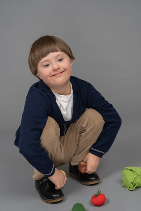 Porträt eines kleinen jungen, der mit gefülltem gemüse spielt