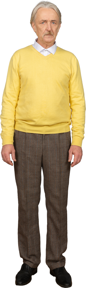 Vorderansicht eines unzufriedenen alten mannes, der gelben pullover trägt und kamera betrachtet