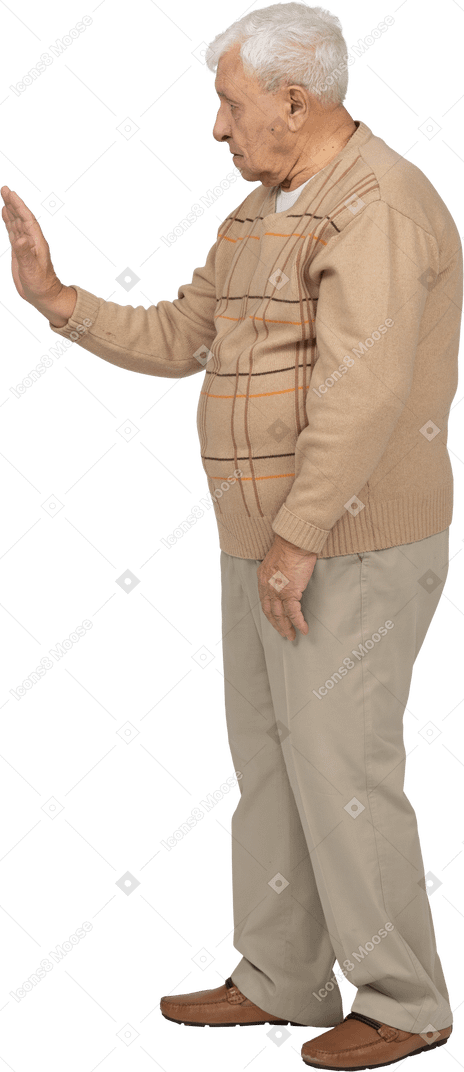 Side view of an old man in casual clothes showing stop gesture