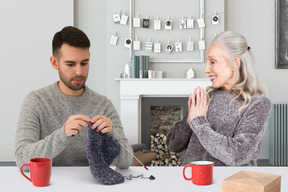 Man knitting next to a smiling woman