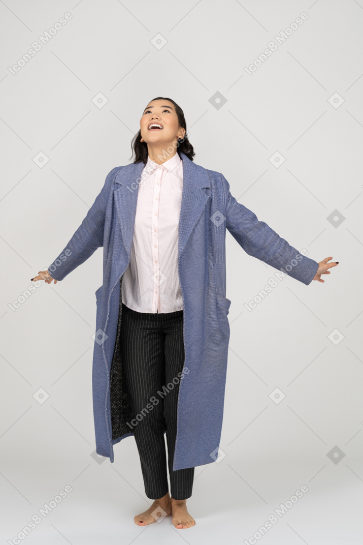 Excited woman spreading hands and looking up