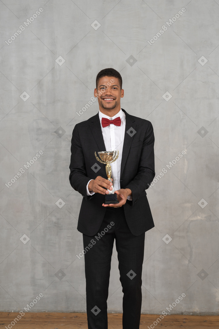 Hombre feliz con traje posando con un premio