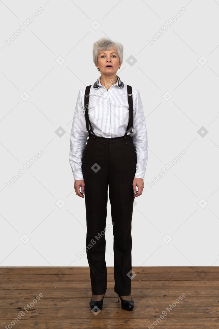 Front view of an old female in office clothes opening mouth in a surprise