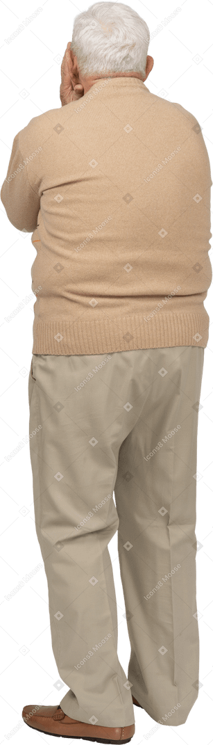 Rear view of an old man in casual clothes covering face with hands