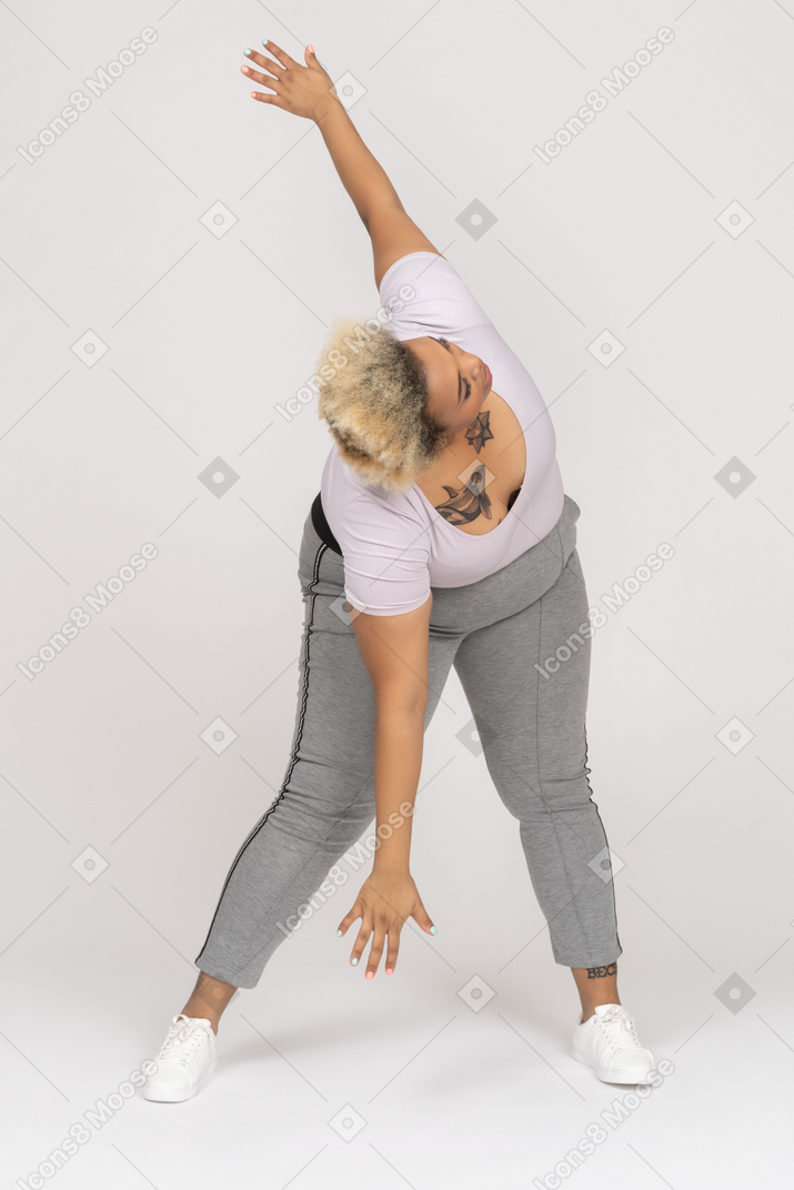 Woman bending forward and making side crunches with outstretched arms