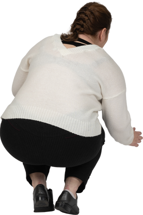 一个穿着休闲服蹲着的胖女人的后视图