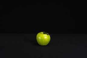 Une pomme verte solitaire sur fond noir