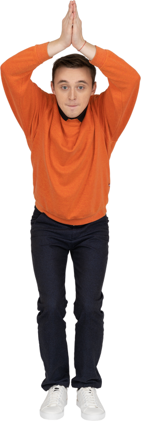 Jeune homme en sweat-shirt orange posant