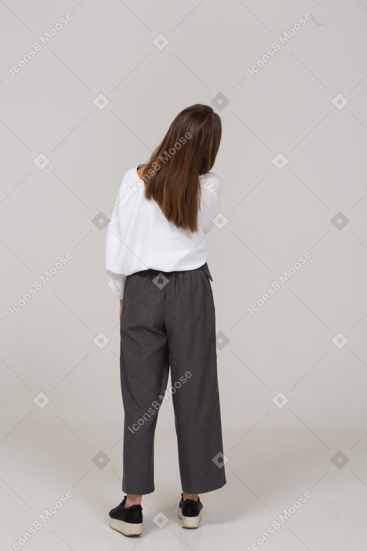 Back view of a young lady in office clothing tilting head