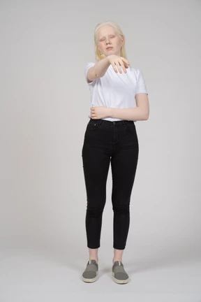 Woman pointing with eyes closed