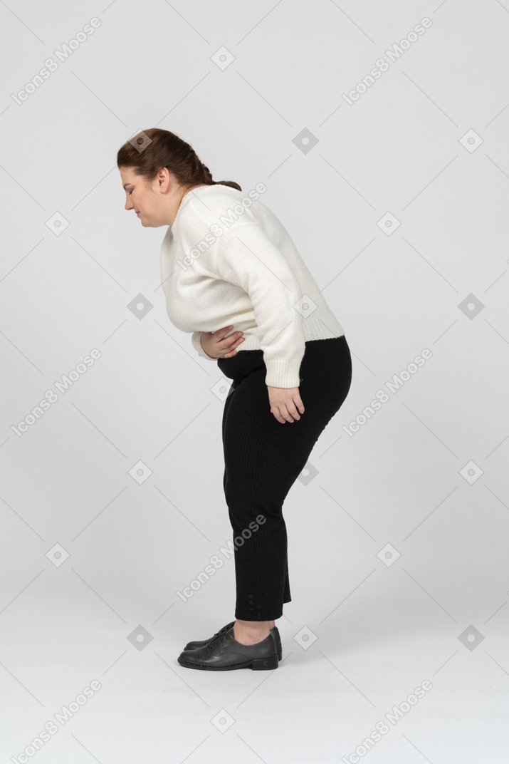 Plus size woman in casual clothes suffering from stomachache