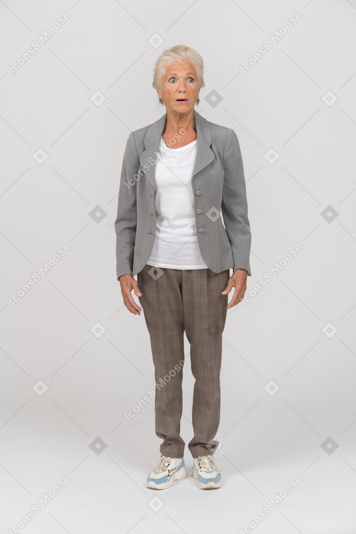 Vista frontale di una donna anziana scioccata in abito che fissa qualcosa